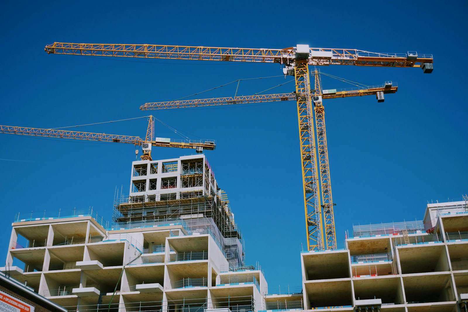 Cranes above an apartment block under construction
