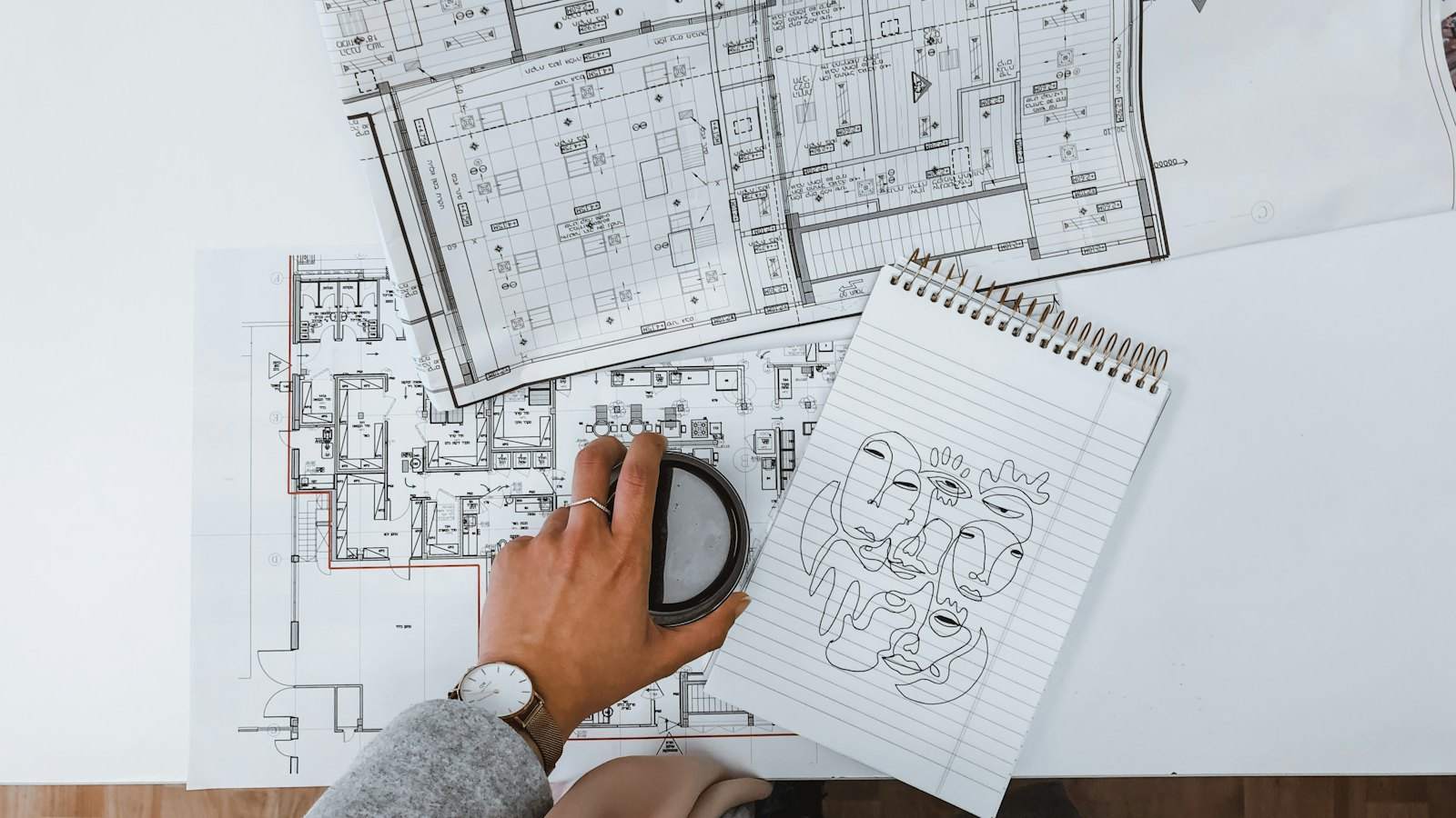 Hands reviewing building plans and floor layouts