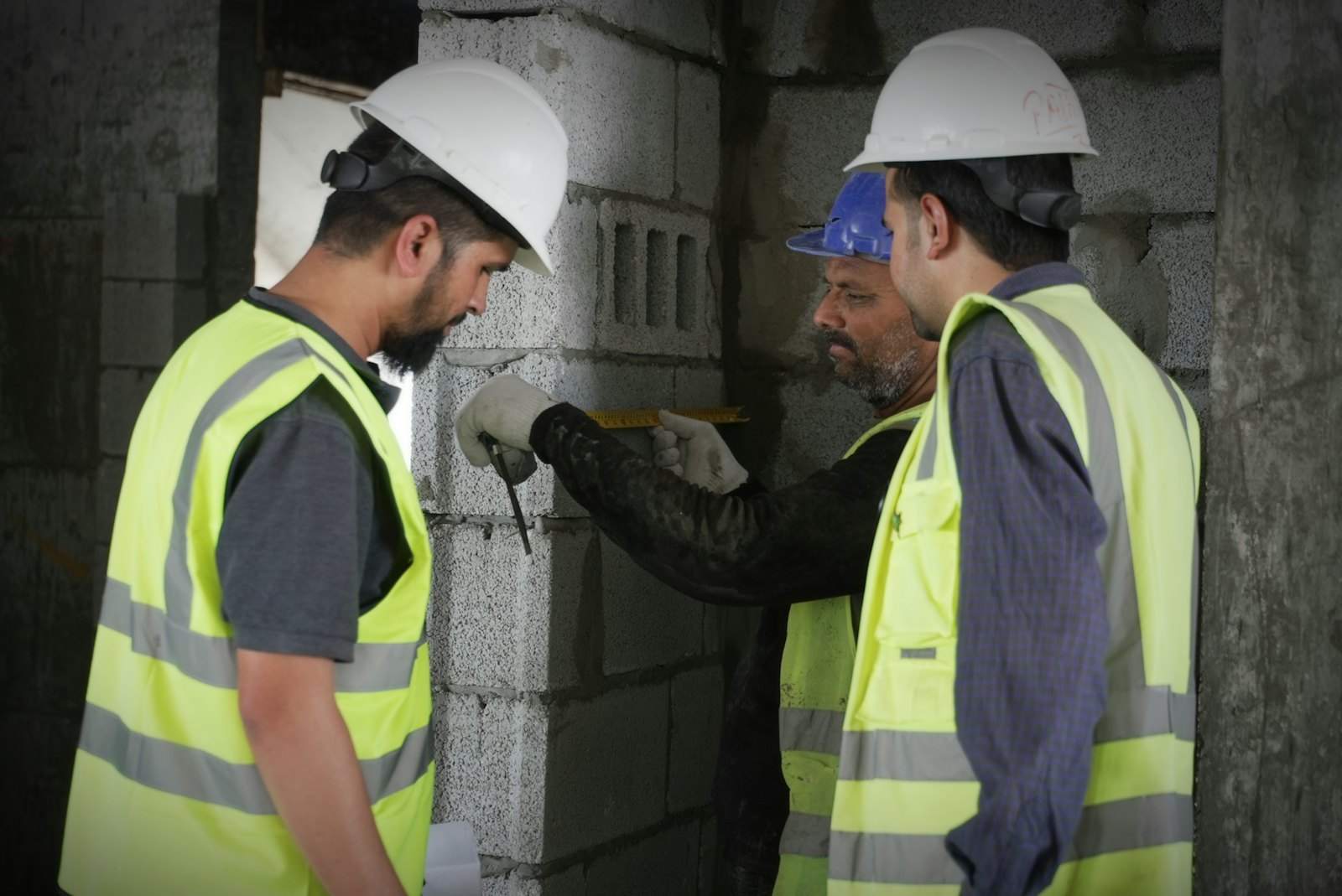 Warranty surveyors inspecting blockwork on a building site
